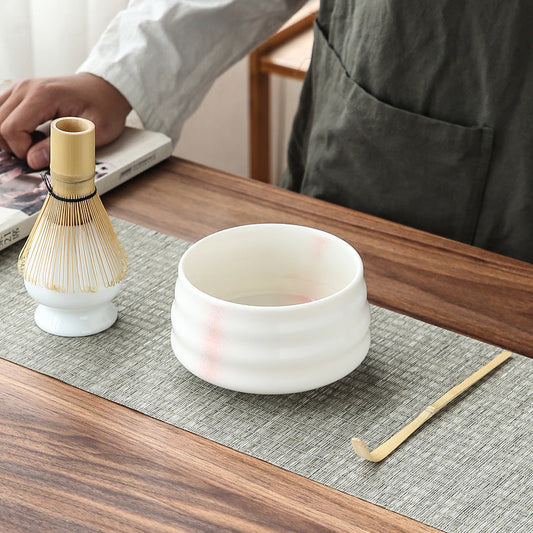 Traditional matcha tea set with bamboo whisk.